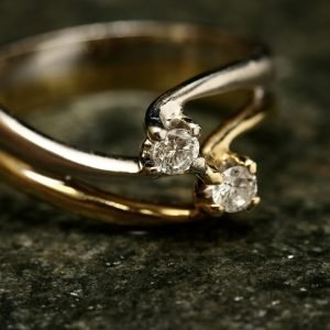 Close-up of an exquisite diamond ring with gold and platinum bands symbolizing luxury and elegance.